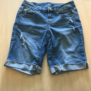 A pair of long jean shorts
